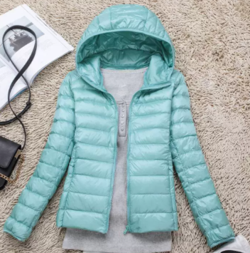 Close-up of a women's lightweight hooded puffer jacket, showing quilted texture & durable design.