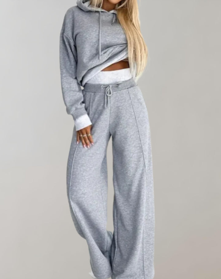Casual women's streetwear two-piece set with a modern hoodie and flowing wide-leg trousers.