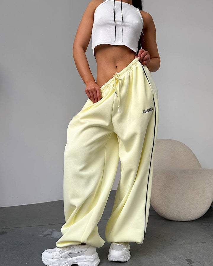 Model wearing women's wide leg sweatpants with side stripe, perfect for casual outings.