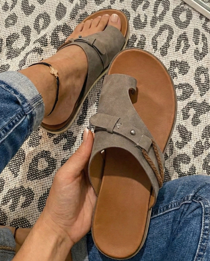 Comfortable brown flat toe loop sandals, ideal casual footwear for holiday trips.