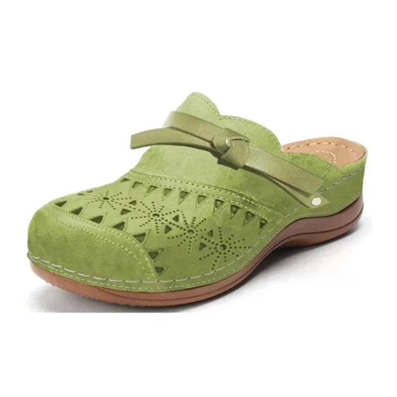 Women's elegant slip-on clogs with a distinctive bow accent and trendy cutout detailing. Stylish summer footwear.