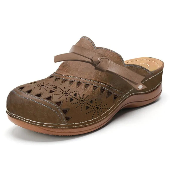 Women's stylish slip-on clogs, featuring a charming bow and intricate cutouts. Comfortable casual summer footwear.