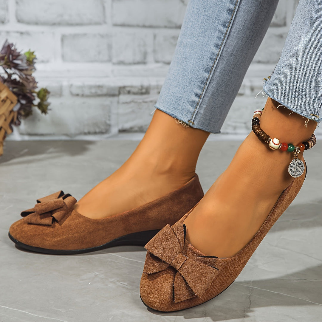Classic women's shoes: wedge ballet flats with bow detail, combining comfort and style.