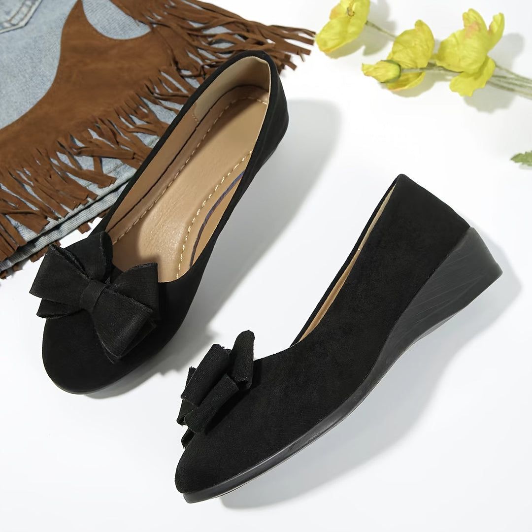 Women's comfortable slip-on wedge flats with a stylish bow, versatile for casual occasions.