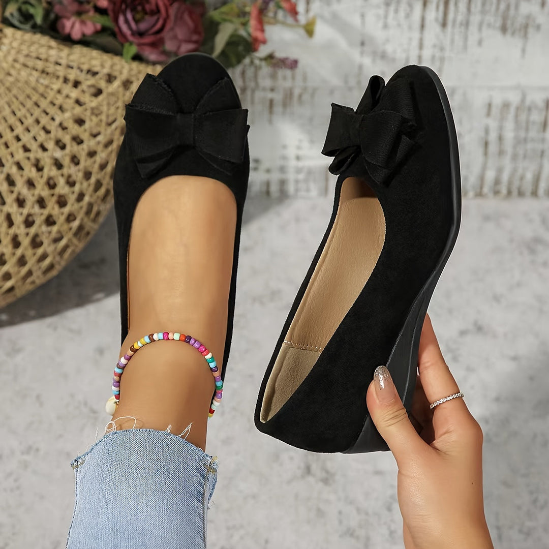 Classic women's wedge ballet flats with a chic bow, offering effortless slip-on comfort.