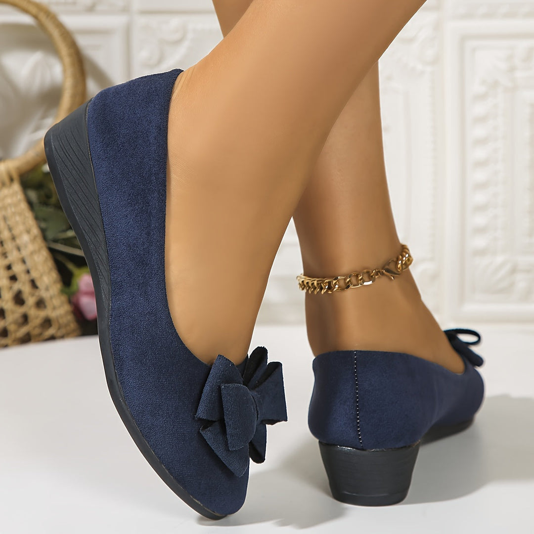 Elegant women's slip-on wedge flats with bow detail, perfect for effortless style and comfort.