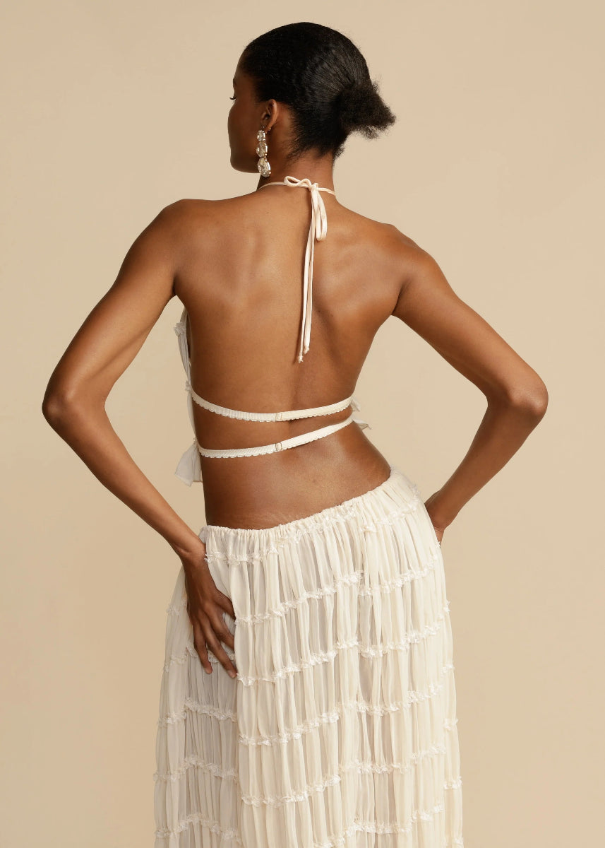 White breezy women's two-piece summer set, halter top & long maxi skirt, perfect for sunny days.