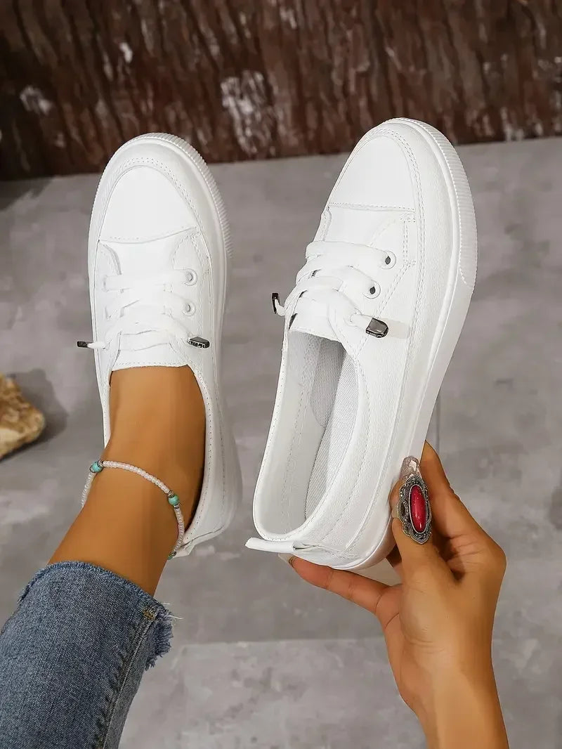 Comfortable women's white lace-up casual flats. Ideal everyday footwear for walking and versatile style.