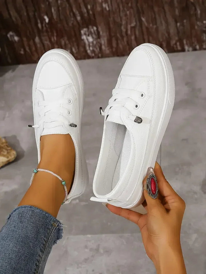 Comfortable women's white lace-up casual flats. Ideal everyday footwear for walking and versatile style.