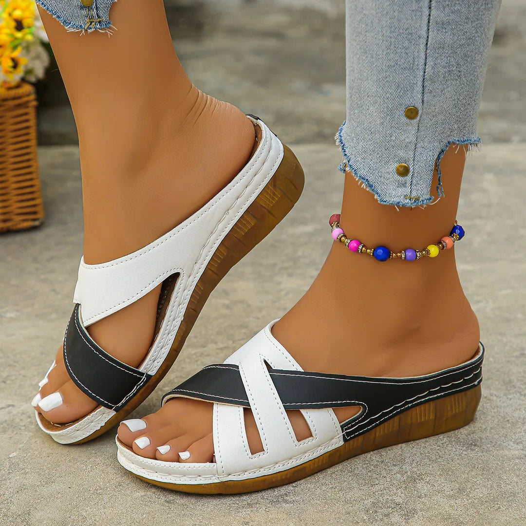 Women's low heel dress sandals showcasing a classic cross-strap detail.