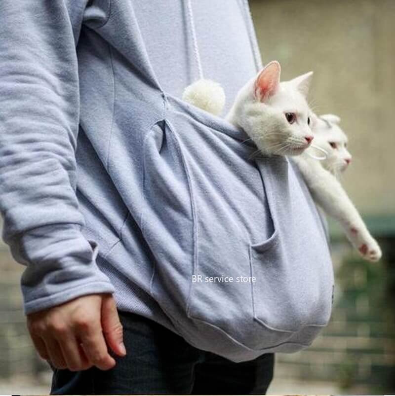 Woman enjoying her cat snuggled in a CozyPurr pet carrier hoodie pouch for ultimate comfort.
