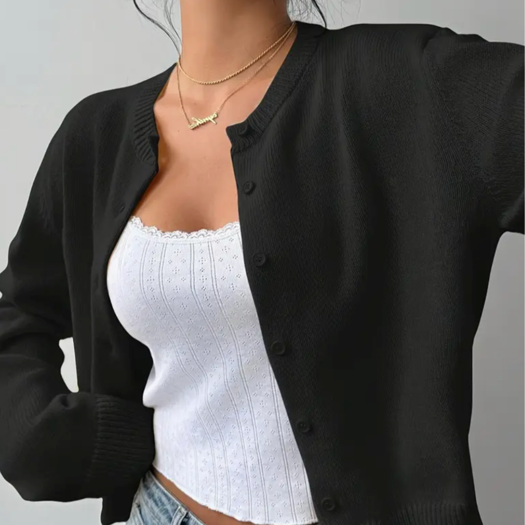 Detailed view of women's cropped cardigan, highlighting ribbed cuffs & classic button front.