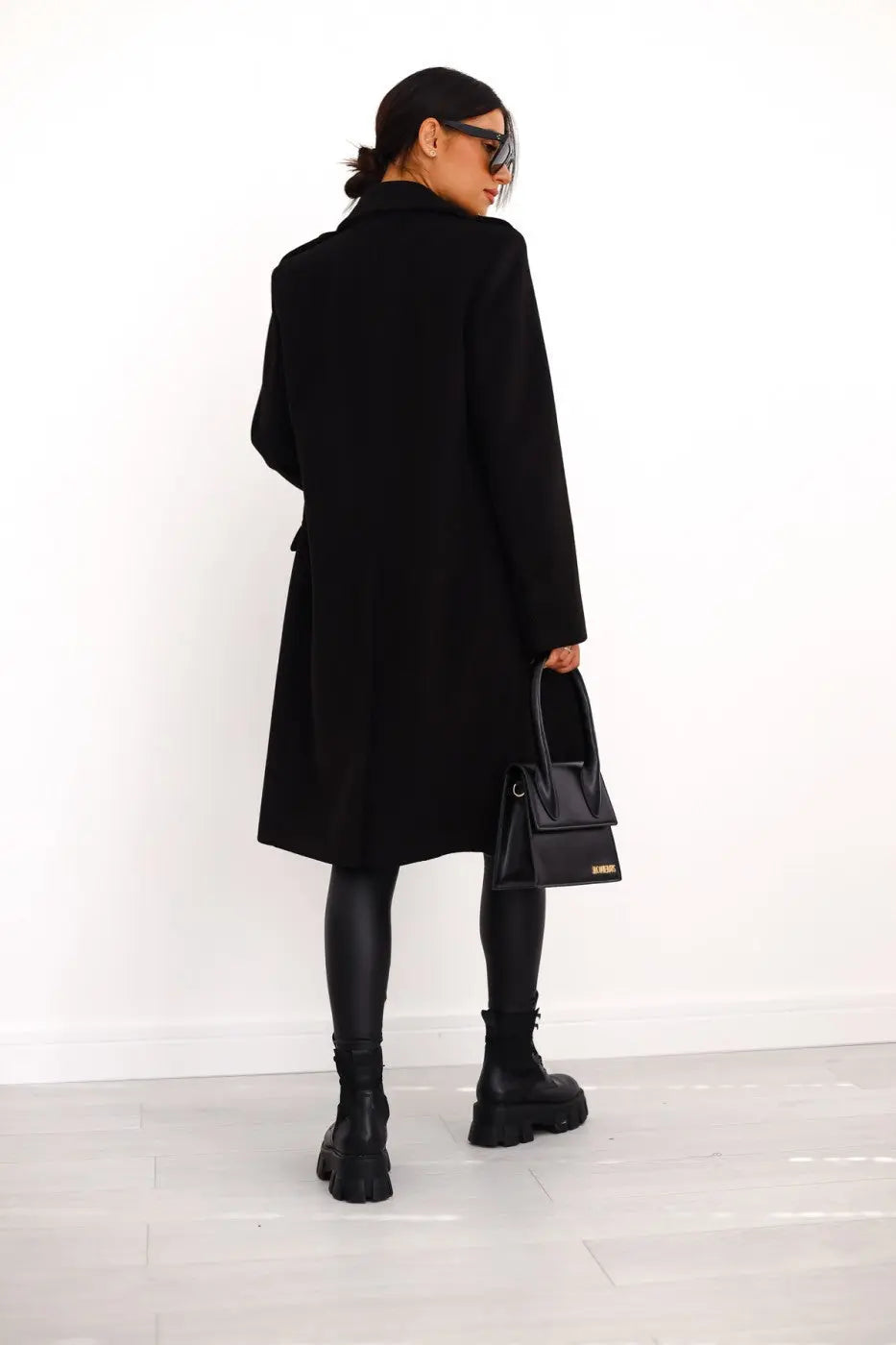 Chic women's long tailored coat, double-breasted, with striking gold buttons for fall/winter style.