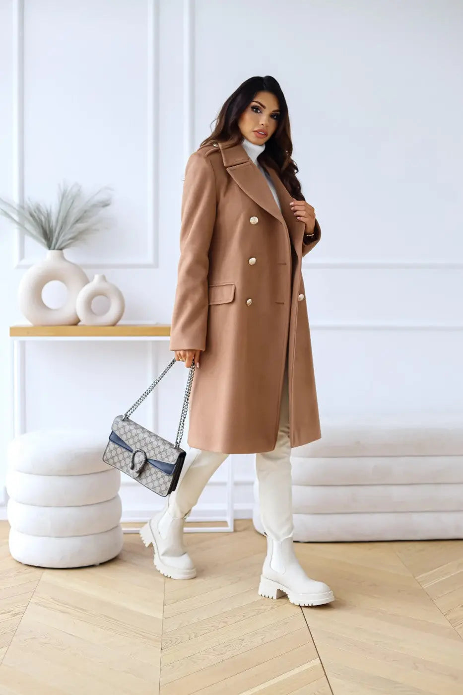 Sleek women's double-breasted long tailored coat with shiny gold buttons, ideal for elegant outerwear.