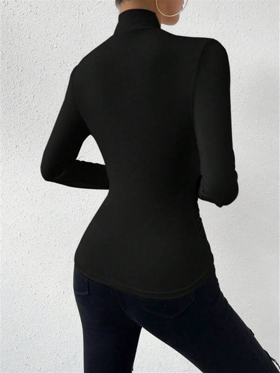 Fashionable women's top with draped crossover detail and long sleeves.