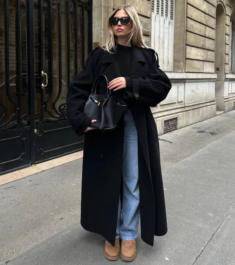 Chic women's black longline coat with classic double-breasted design, ideal for urban outerwear.