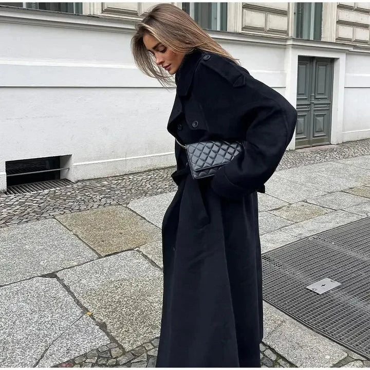 Timeless sophisticated women's double-breasted black coat, offering an elegant longline silhouette.