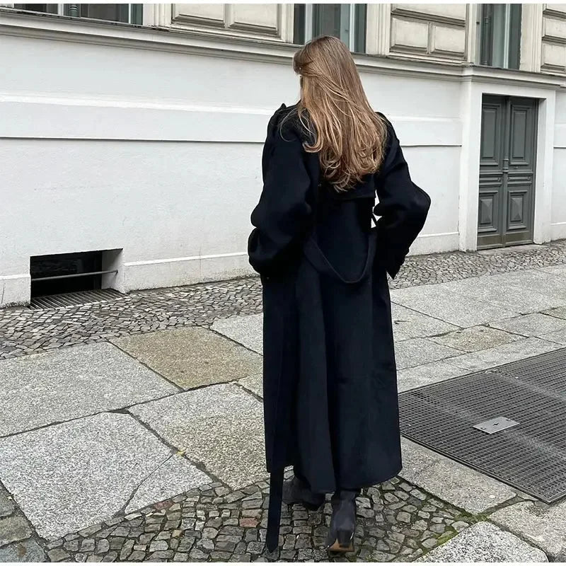 Elegant women's fashion black coat, double-breasted and longline, suitable for chic winter outfits.