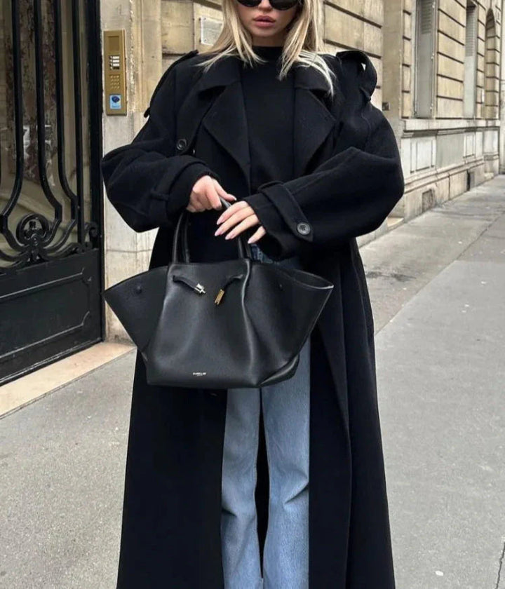 Women's longline black coat, double-breasted for a chic, timeless look. Perfect elegant winter fashion.
