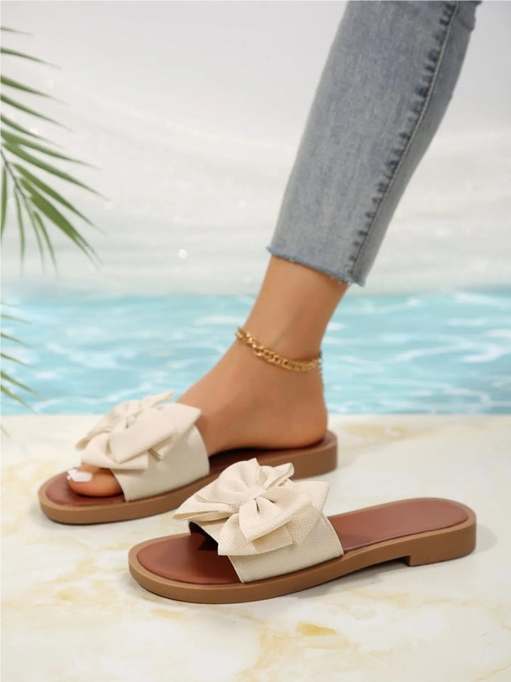 Comfortable women's flat slide sandals featuring a stylish bow accent, ideal for everyday elegance.