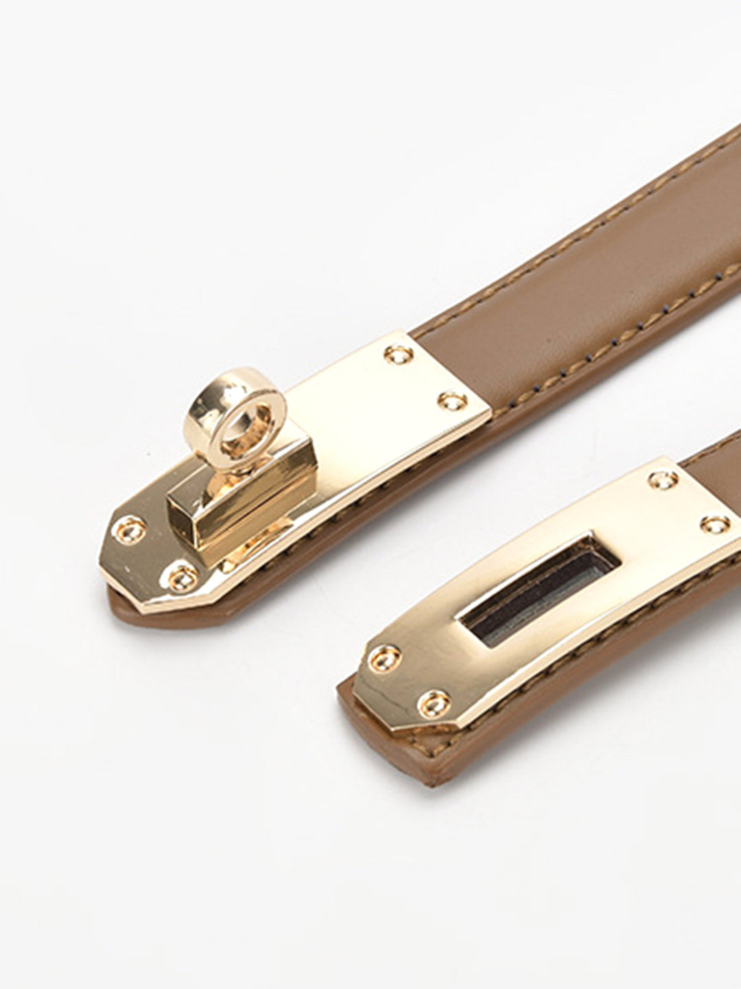 Close-up of the polished gold twist lock detail on a women's fashion waist belt