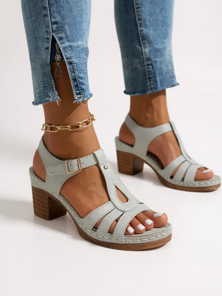 A pair of elegant women's block heel sandals in a neutral tone, versatile footwear.