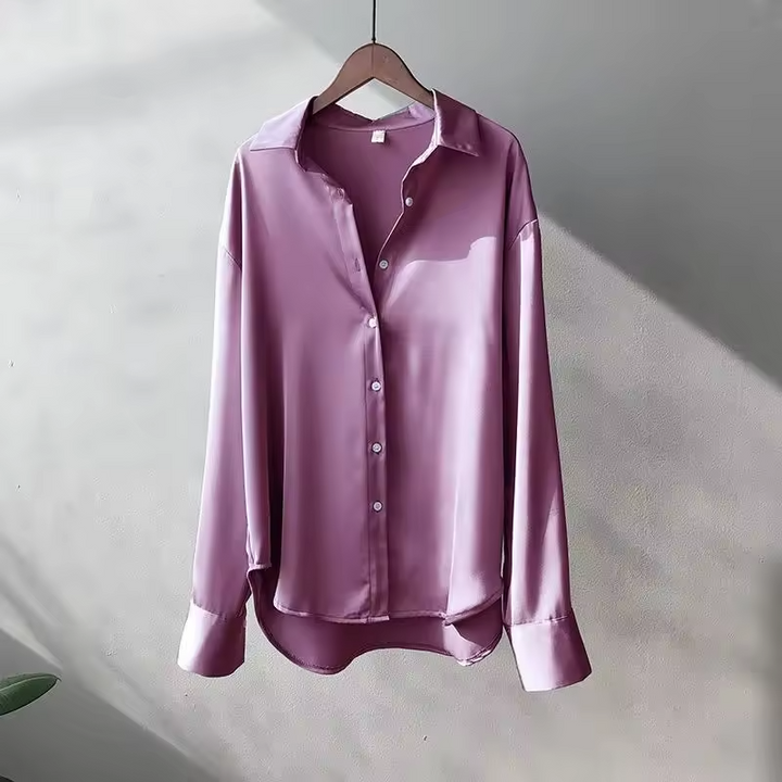 A woman styled in a pale pink elegant silk blouse, perfect for casual and work outfits.