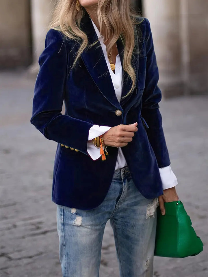 Model wearing a women's elegant velvet blazer in a sophisticated evening setting.