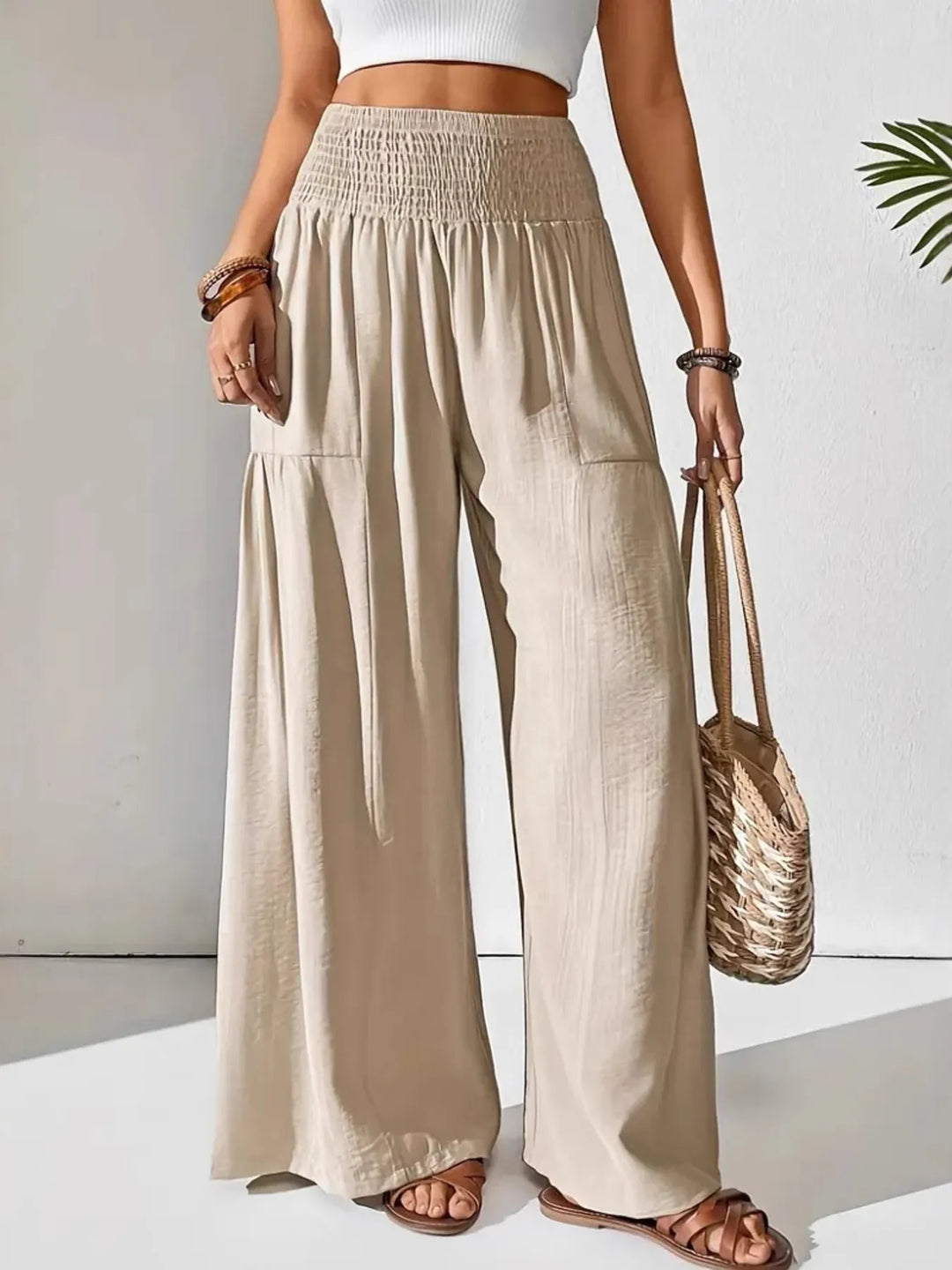 Women's flowy smocked waist wide leg pants in black, perfect for summer fashion.