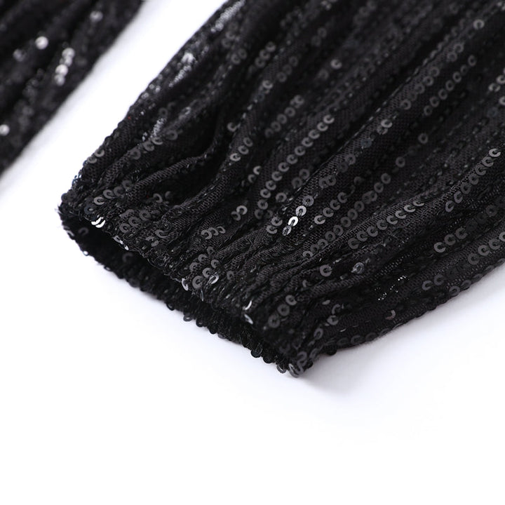 A close-up of the intricate gold sequin detailing on a women's cocktail dress.