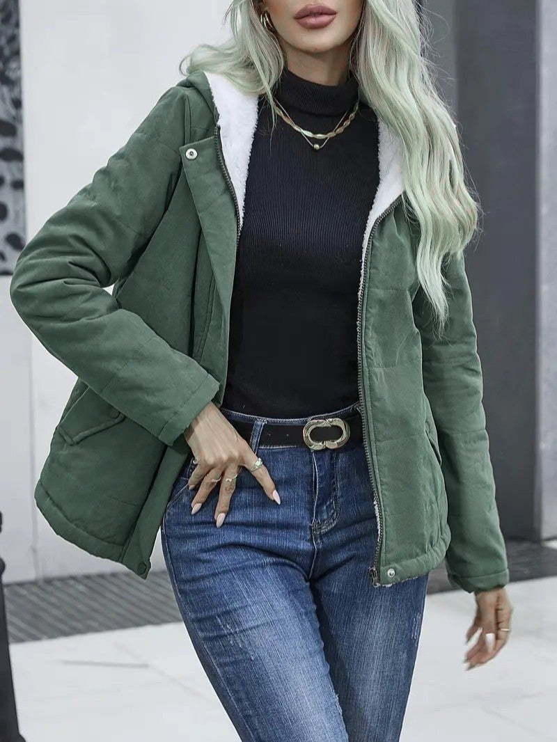 Woman layering a warm, lined zip-up jacket over a sweater for winter.