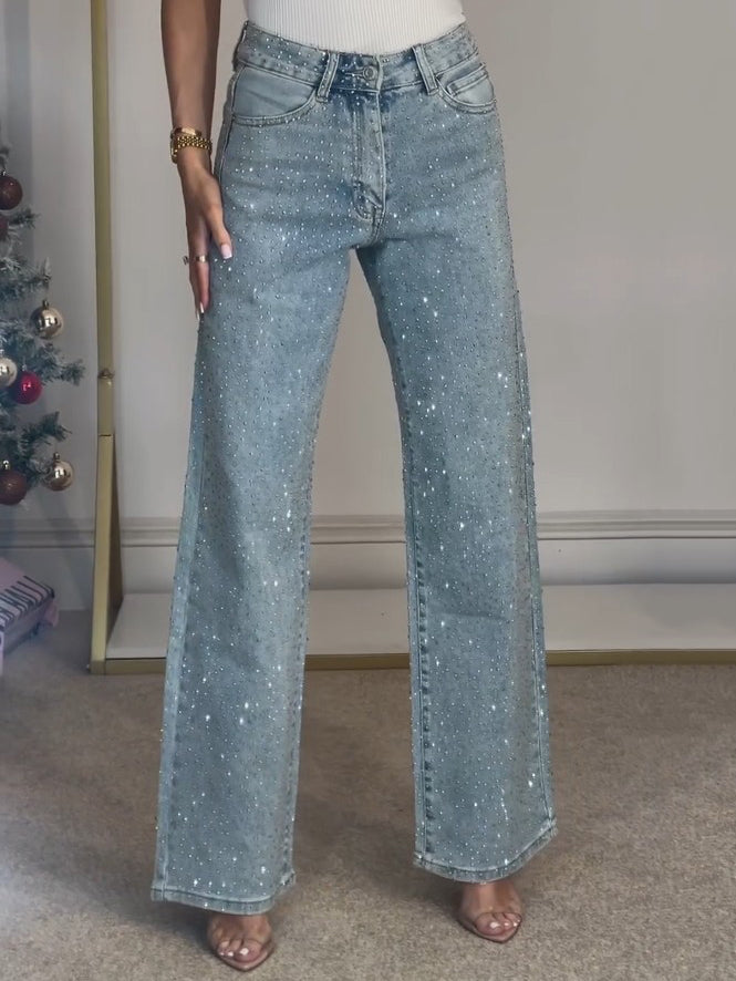 Close-up of diamanté details on women's light blue high waist straight leg jeans.