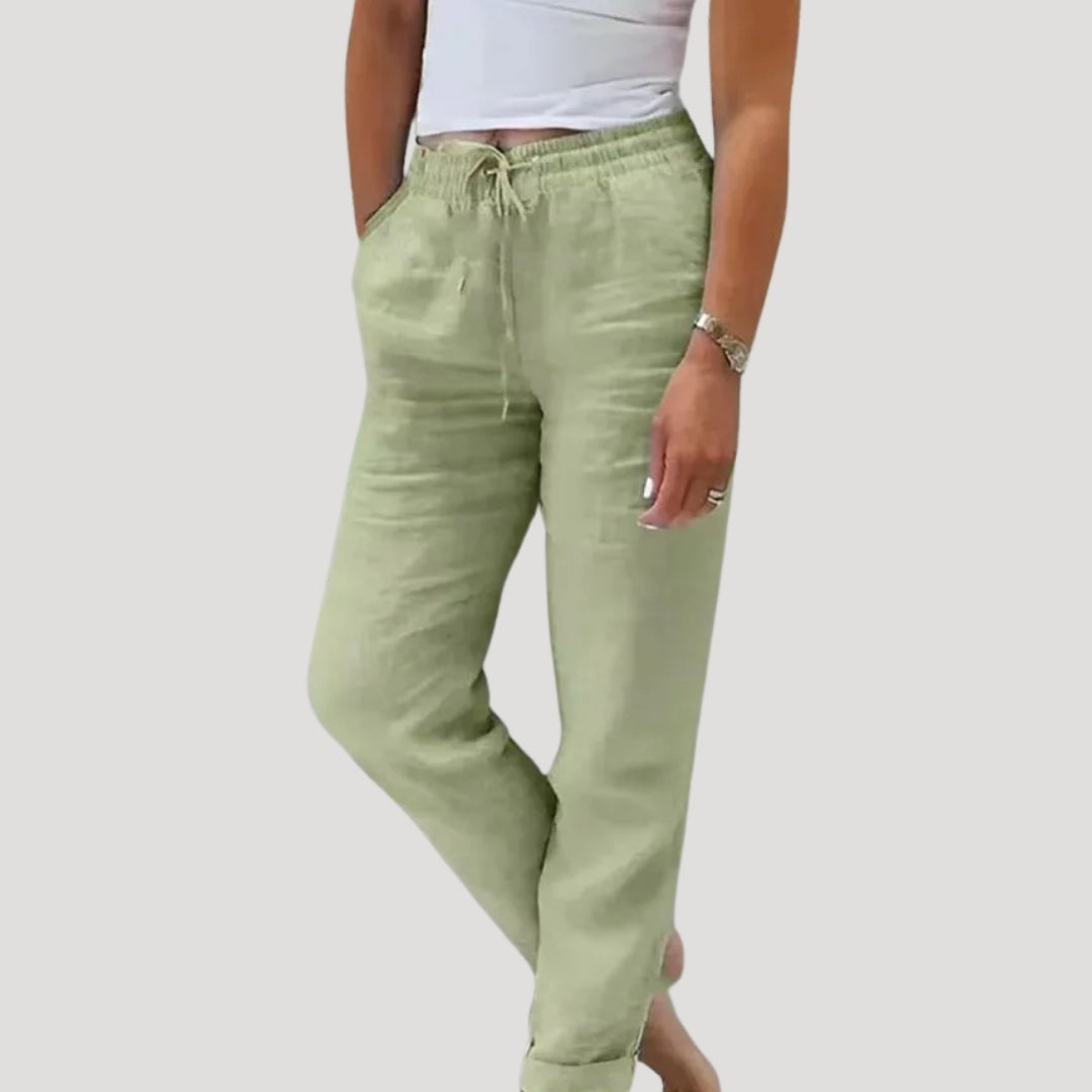 Woman enjoying a beach vacation in comfortable, lightweight women's linen trousers. Perfect summer beachwear.