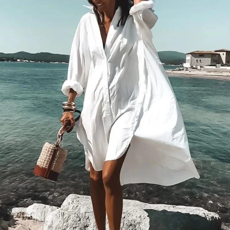 Women's long sleeve beach cover-up top in white, flowy fabric for elegant sun protection on vacation.