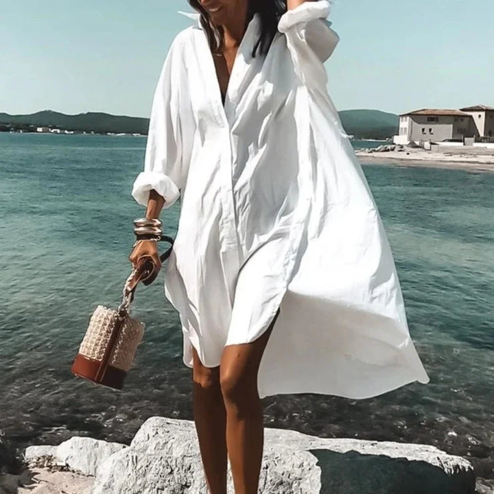 Women's long sleeve beach cover-up top in white, flowy fabric for elegant sun protection on vacation.