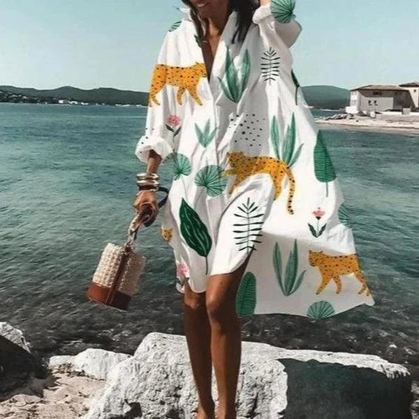 Model wearing a women's long sleeve beach cover-up on the beach, perfect for elegant sun protection & resort wear.