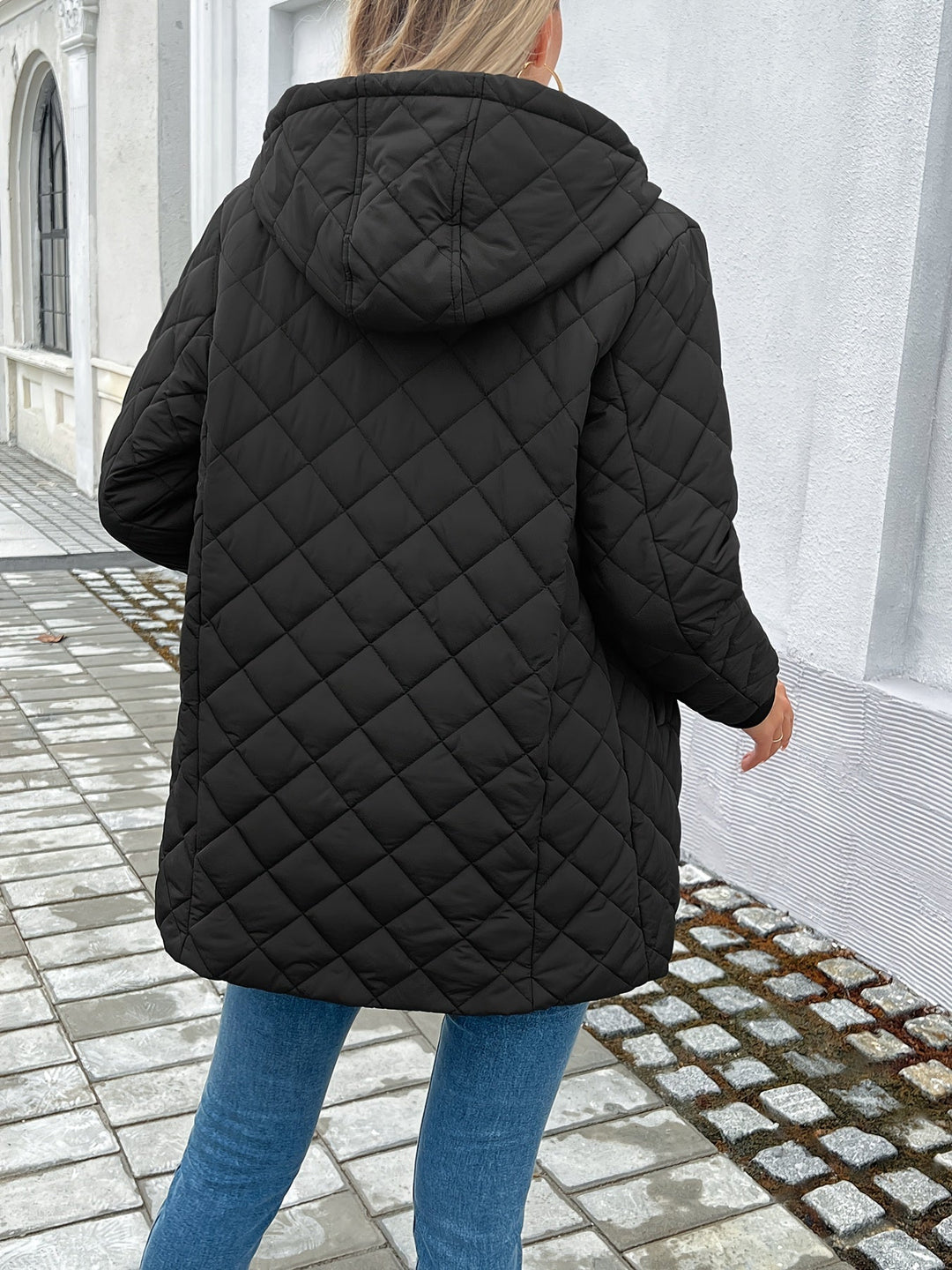 Warm women's hooded quilted longline coat. Features a secure zip closure, perfect stylish outerwear for winter.