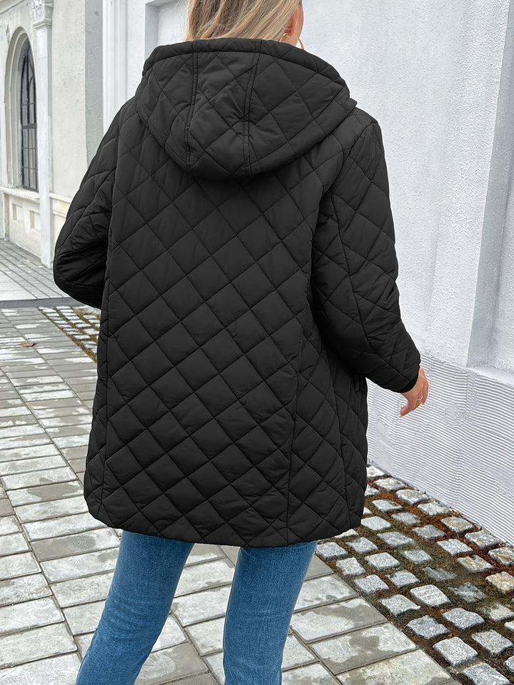 Warm women's hooded quilted longline coat. Features a secure zip closure, perfect stylish outerwear for winter.