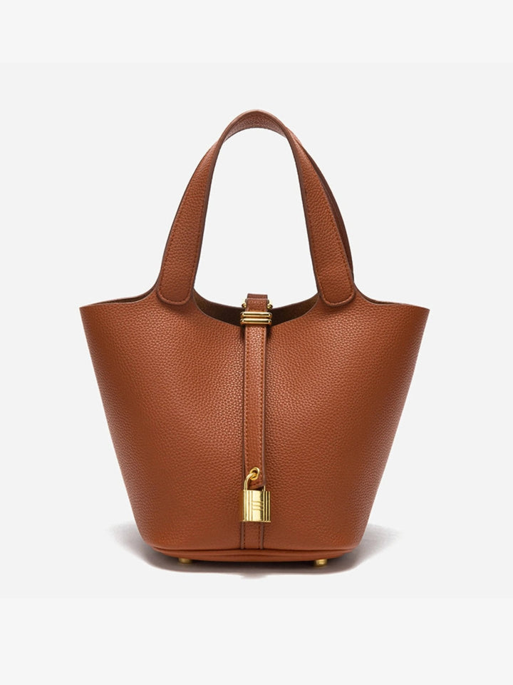Gold hardware detail on a women's taupe leather bucket bag