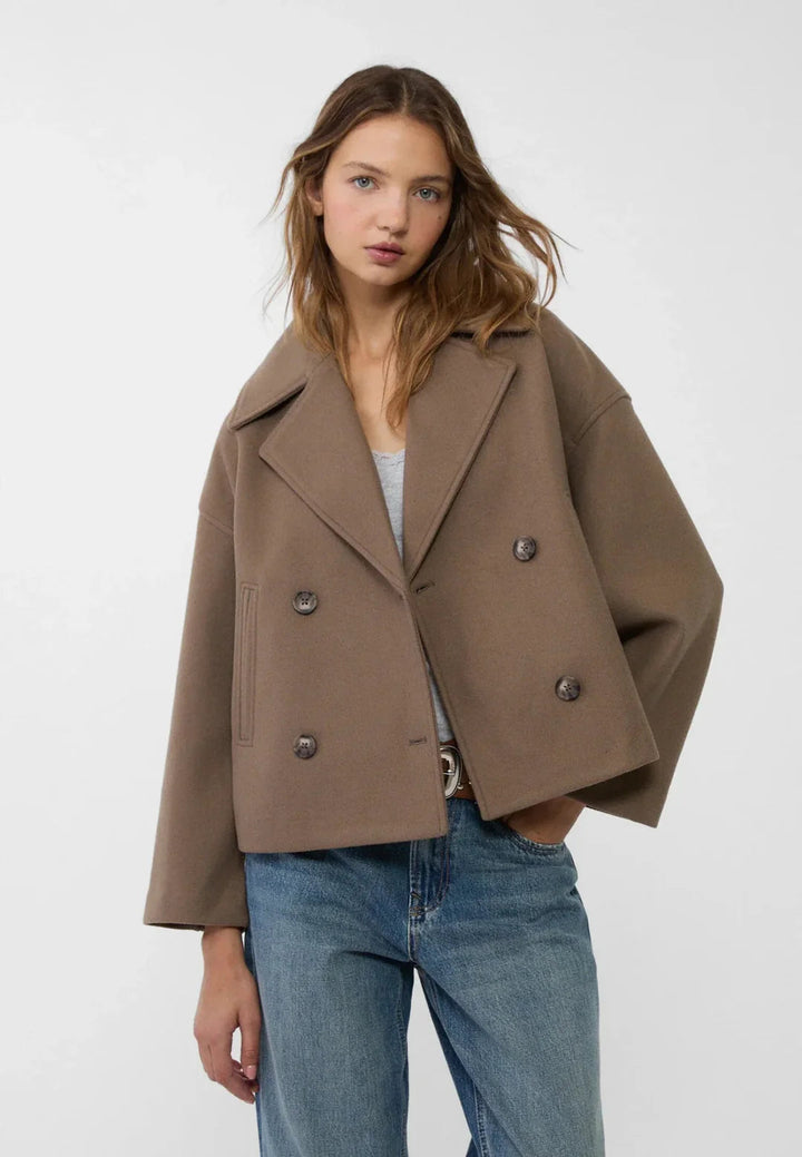 Modern cropped double-breasted women's jacket, chic outerwear for fall and winter fashion.