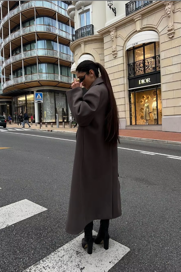 Modern women's brown oversized longline coat. Double-breasted winter outerwear for a chic and stylish look.