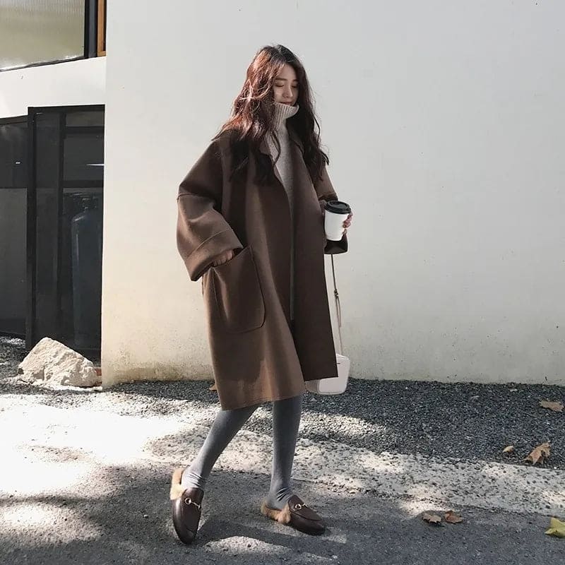 Elegant women's long oversized trench coat, made from a wool blend, featuring a stylish belted waist.