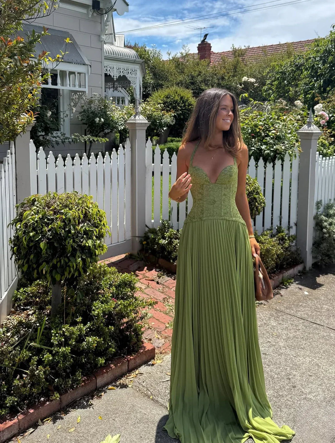 Chic women's halter pleated maxi dress for wedding guests. Elegant evening wear for a summer celebration.