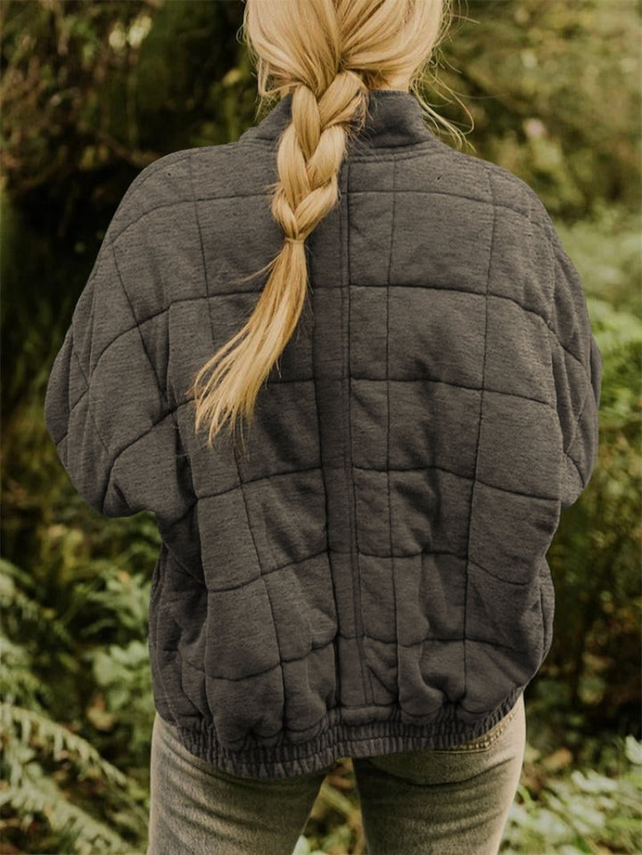 Comfortable women's quilted jacket with zip front, ideal for casual wear & layering.