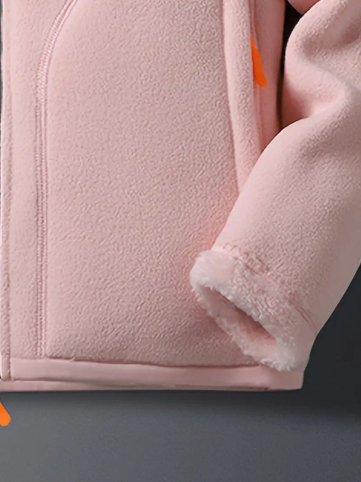 Close-up of a women's cozy reversible winter jacket, showing stand collar and soft fabric detail.