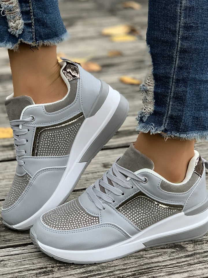 Lace-up closure detail on women's sparkly platform sneakers, highlighting fashion and fit.