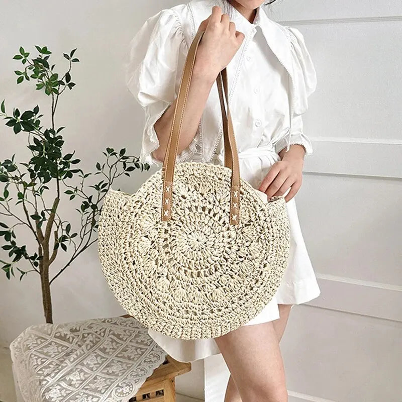 Stylish women's round woven beach tote, shoulder bag for vacation, natural summer handbag.