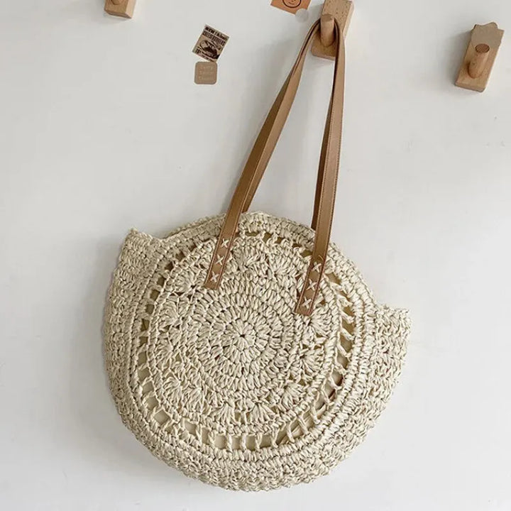 Round woven women's beach tote bag, spacious & stylish for summer vacations, natural handbag look.