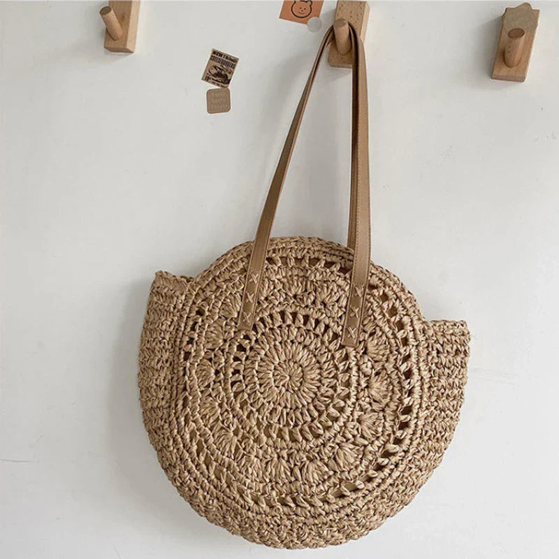 Women's round woven beach tote, a versatile summer shoulder bag for vacations, natural & stylish.