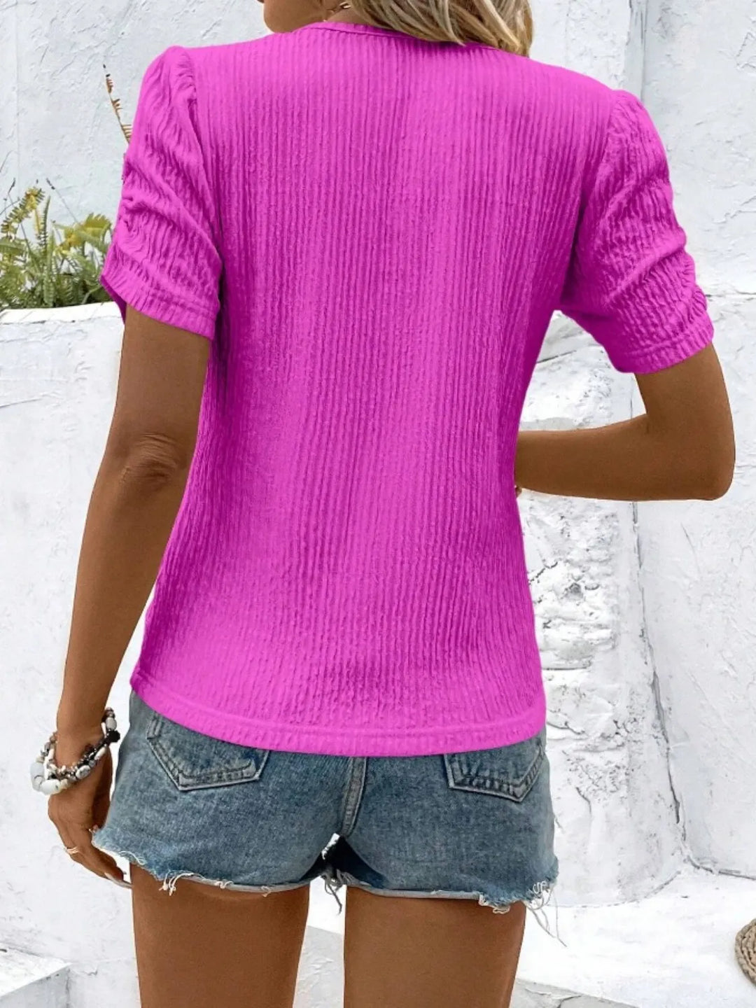Showcasing the elegant drape of the ruched short sleeve knit top